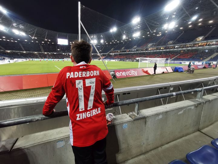 Ein Junge mit einem Zingerle Trikot steht in der HDI-Arena mit Blick auf das Spielfeld