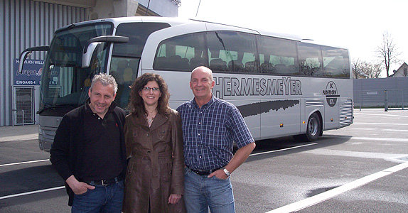 Chef-Trainer Pavel Dotchev, Astrid Hermesmeyer (Taxi Hermesmeyer) und Busfahrer Uwe Hussmann vor dem Mannschaftsbus.